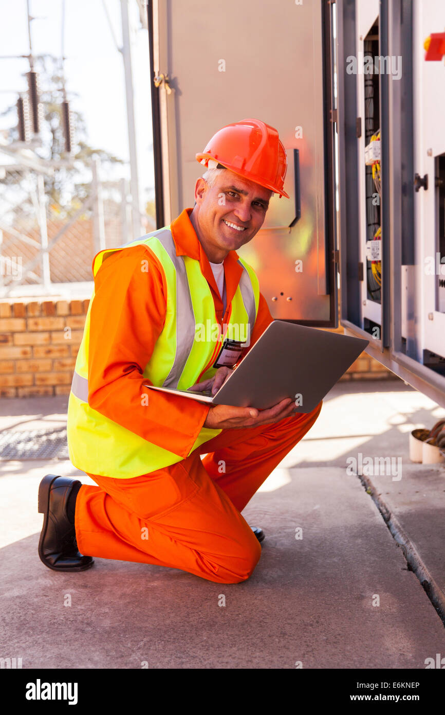 professional senior electrician working in substation Stock Photo