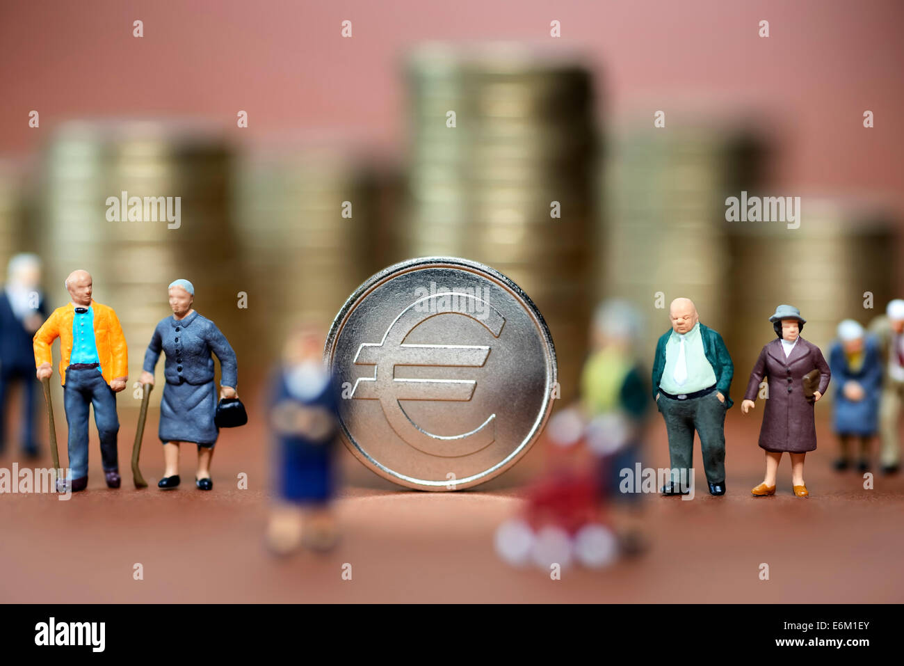 Münze mit Eurozeichen und Miniaturfiguren von Senioren, Symbolfoto Rente Stock Photo