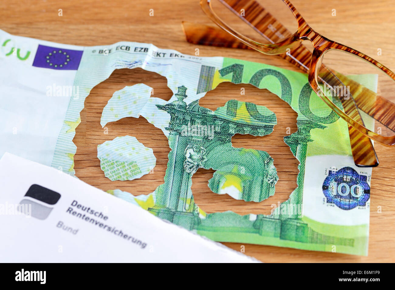 Hundert-Euro-Schein mit herausgerissener Zahl 63, Rente mit 63 Stock Photo