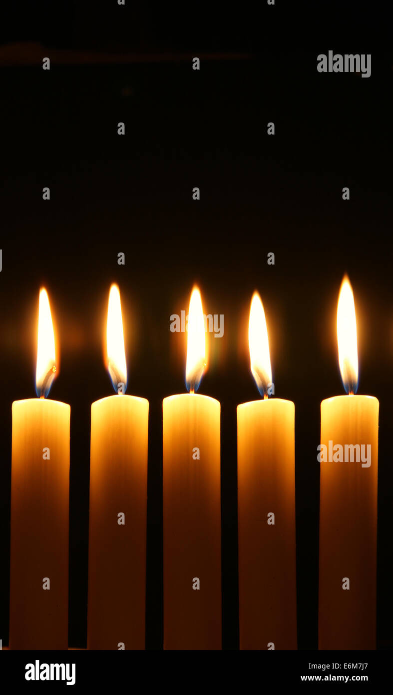 Five burning candles over black background Stock Photo Alamy