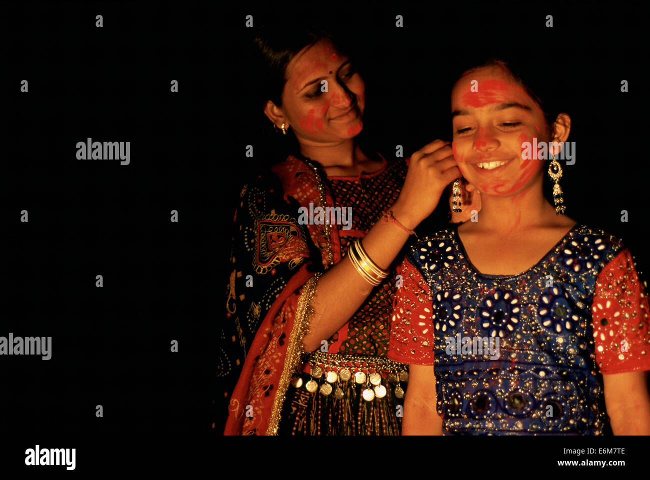 Hindu woman and girl with red powder on their face. They are celebrating the Holi festival ( India) Stock Photo