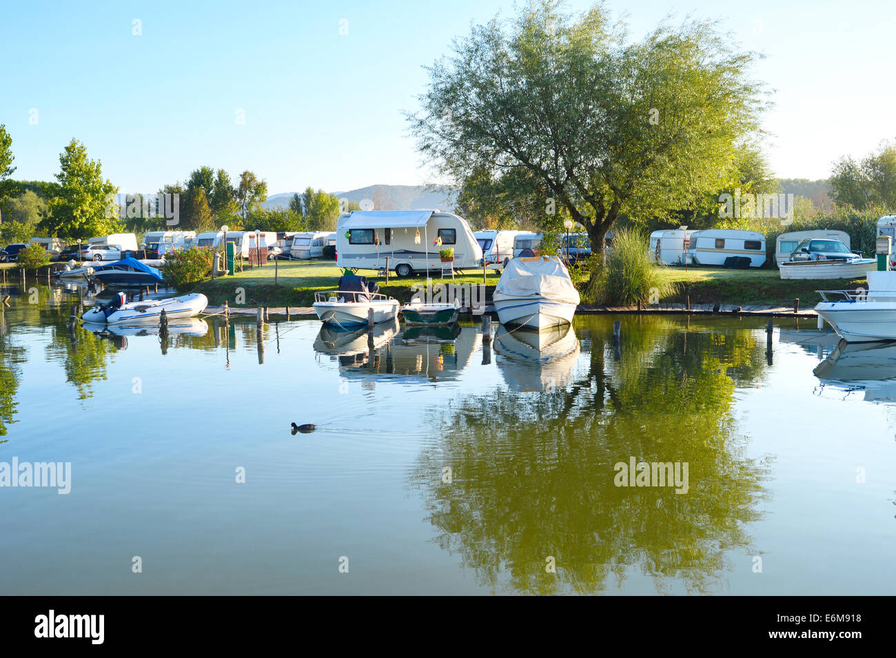 Camping site on a lake with caravans and boats Stock Photo