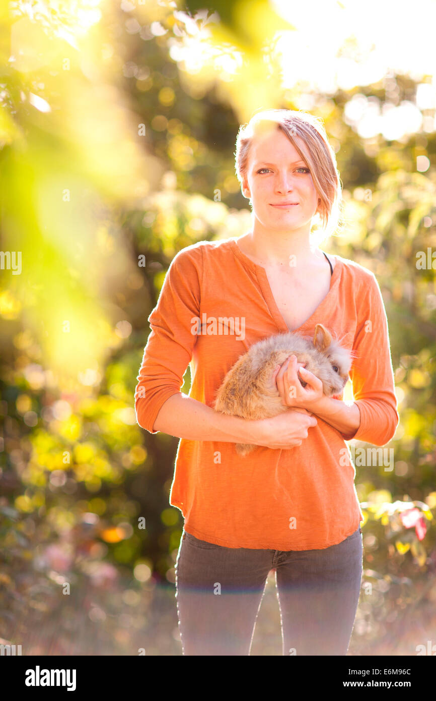 Woman holding rabbit in garden Stock Photo