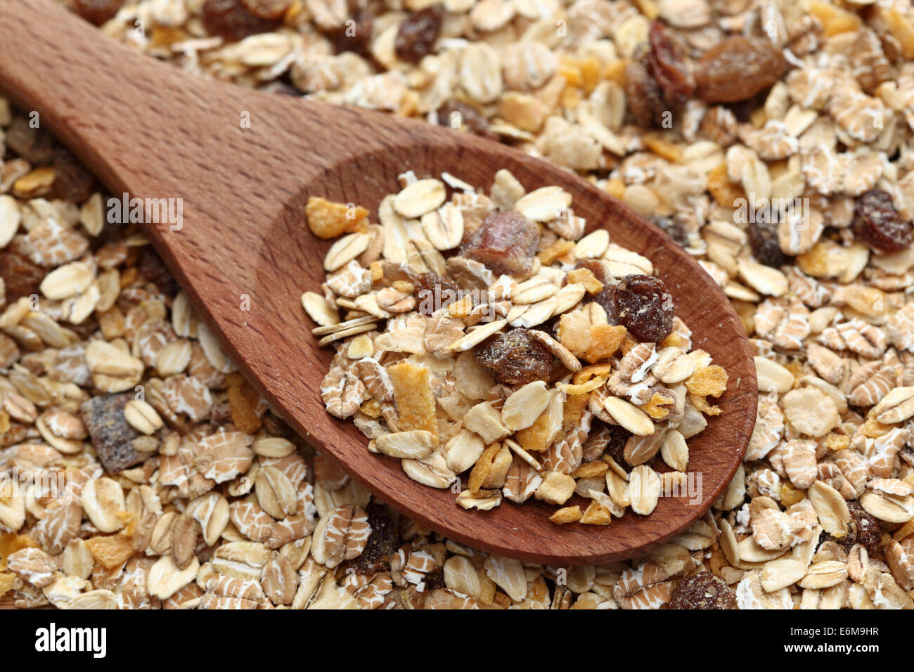 Muesli in a wooden spoon on muesli background. Closeup. Stock Photo