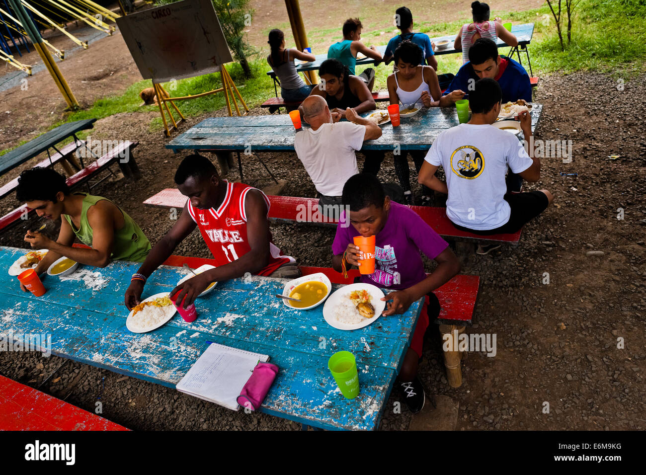 Students eat lunch in an open-air dinner of the circus school Circo para Todos in Cali, Colombia. Stock Photo