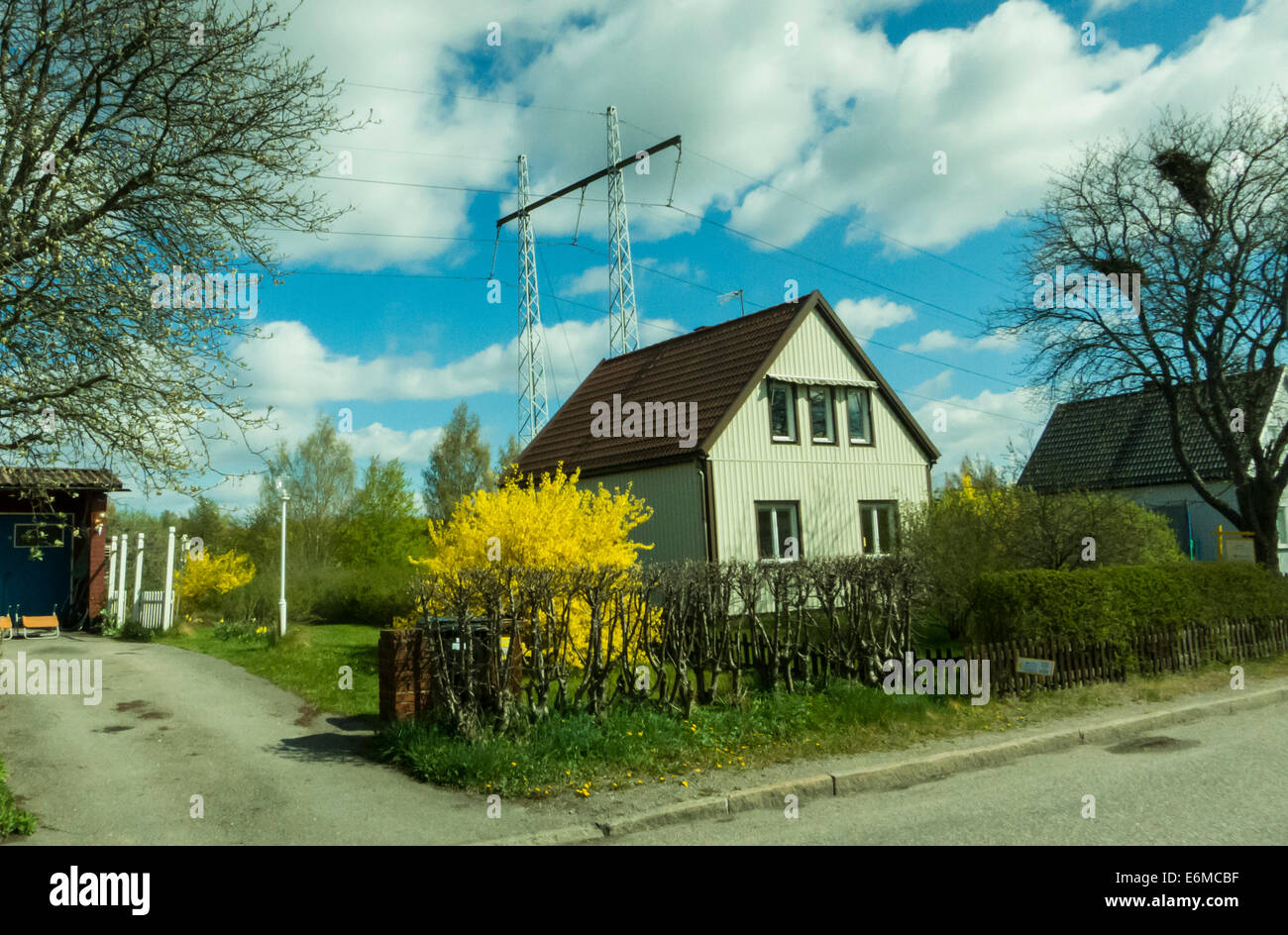 A one-family home next to an overhead power line Stock Photo