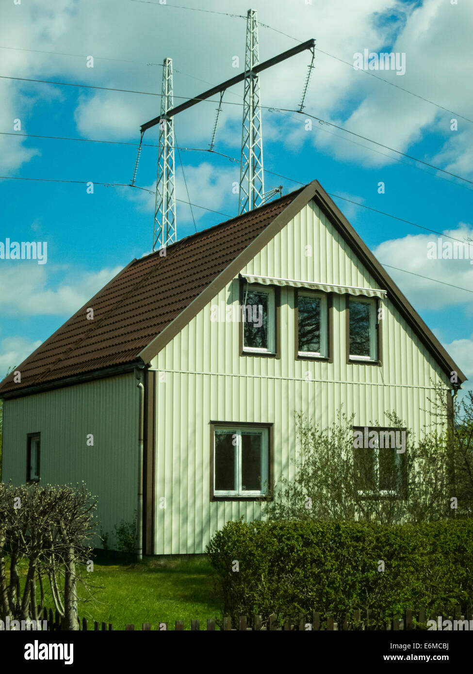 A one-family home next to an overhead power line Stock Photo