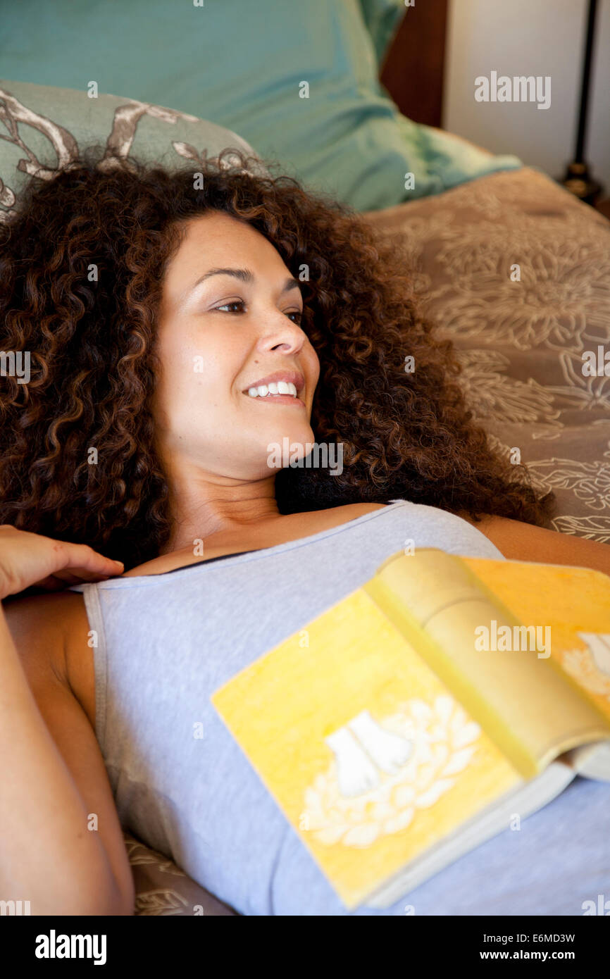 Woman with book on bed Stock Photo