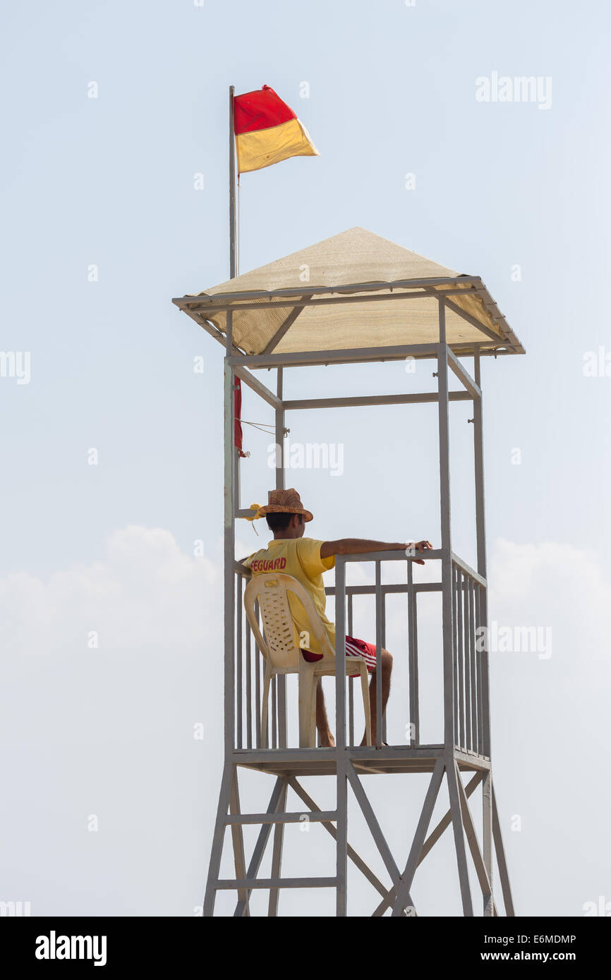 A life guard keeps watch over a beach from a look-out tower Stock Photo