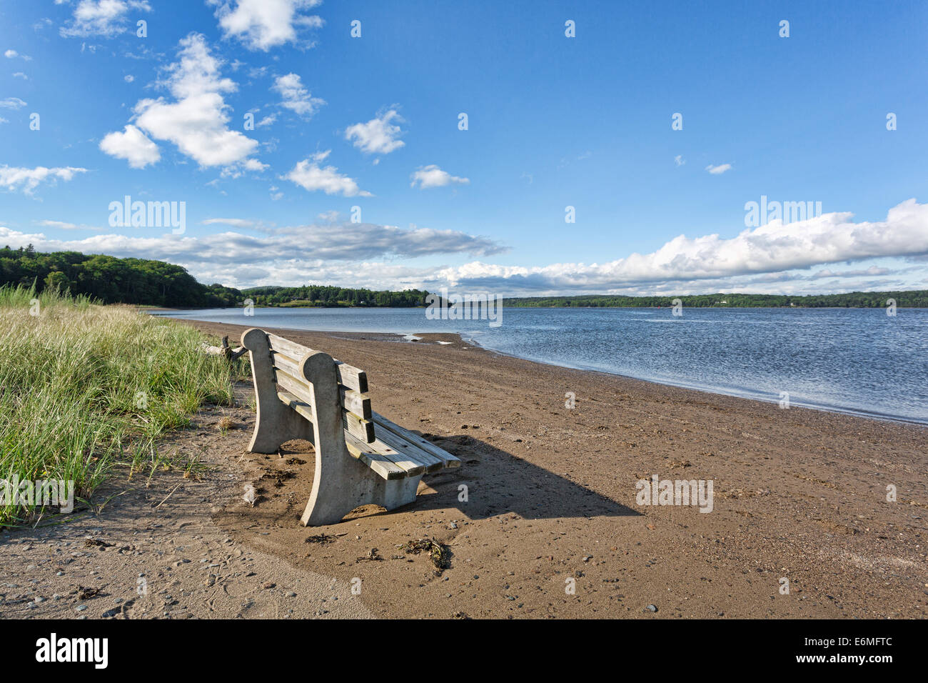 An old concrete and wood bench at Sandy Point Beach facing the Penobscot River in Stockton Springs, Maine Stock Photo