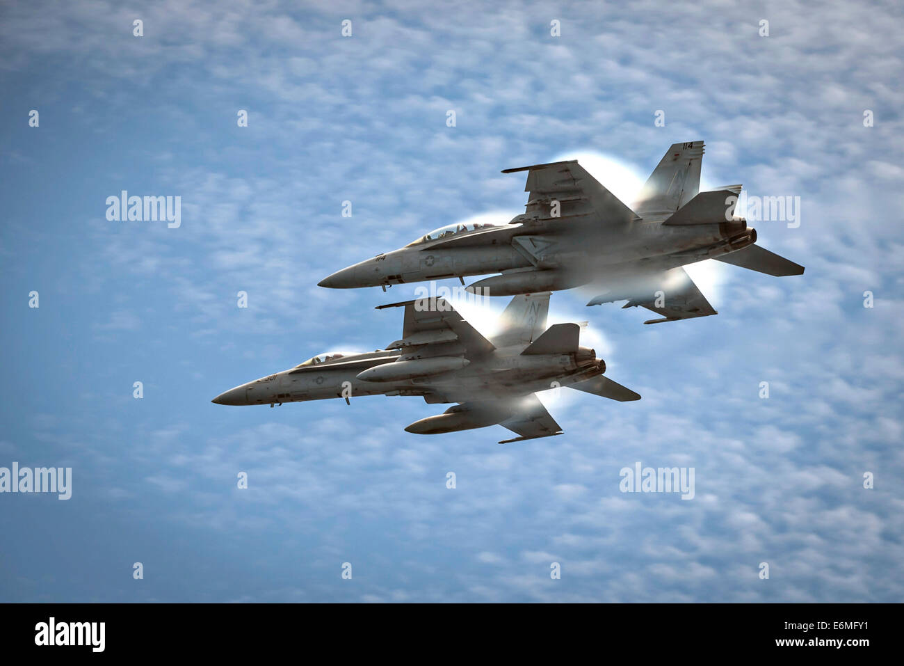 A US Navy F/A-18C Hornet fighter aircraft and a F/A-18E Super Hornet fighter fly in formation over the flight deck of aircraft carrier USS Carl Vinson August 24, 2014 off the coast of Southern California. Stock Photo