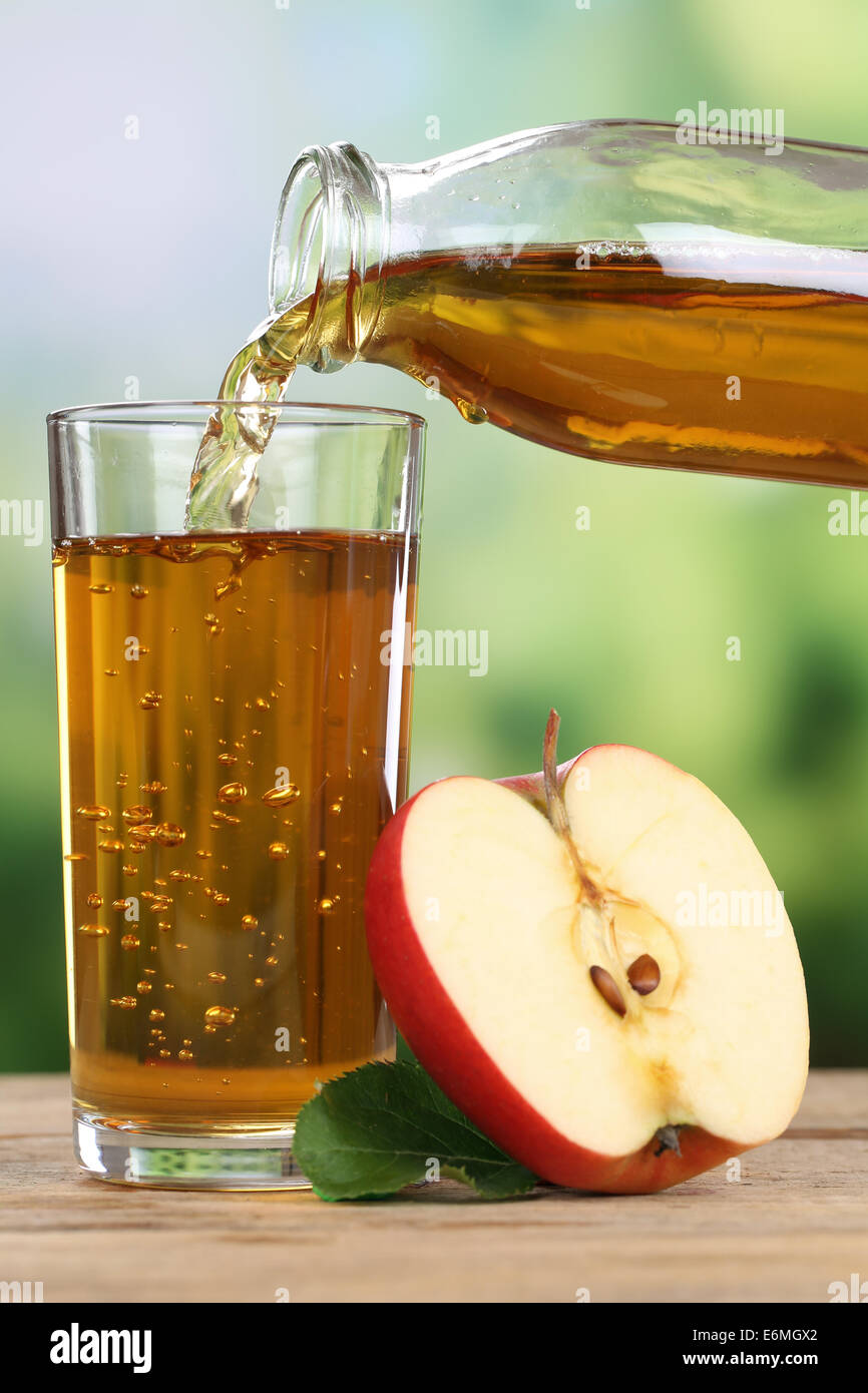 Apple juice pouring from apples fruits in autumn into a glass Stock Photo