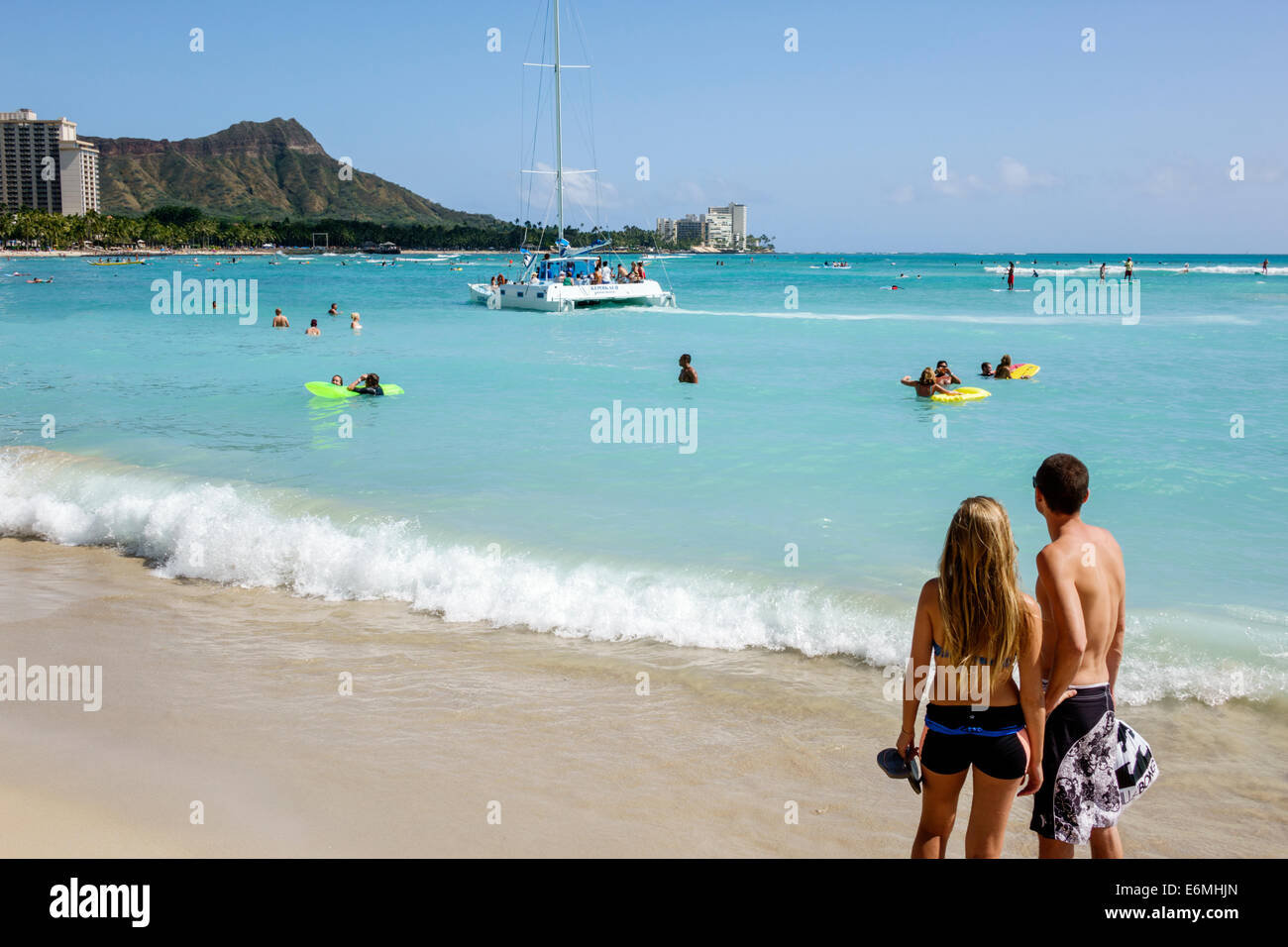 Honolulu Waikiki Beach Hawaii,Hawaiian,Oahu,Pacific Ocean,waterfront,sunbathers,surfboard,woman female women,carrying,surfer,Diamond Head Crater,extin Stock Photo