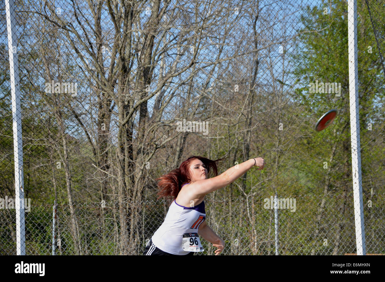 Girl throwing a disk in a high school dicus throwing event at a  track and field event Stock Photo