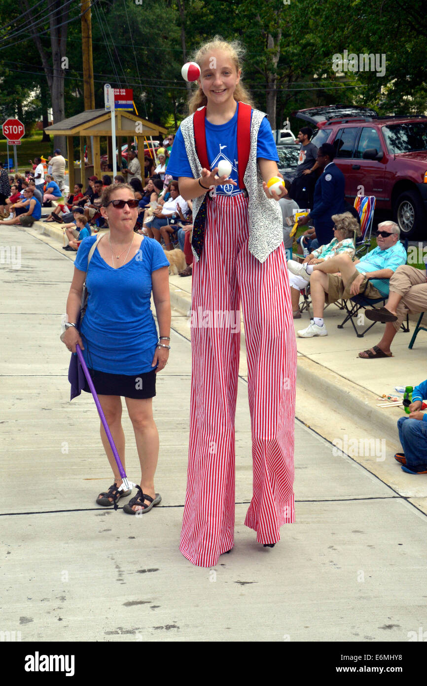 Girl walking on stilts juggles 3 balls while walking in the parade in Greenbelt, Maryland Stock Photo