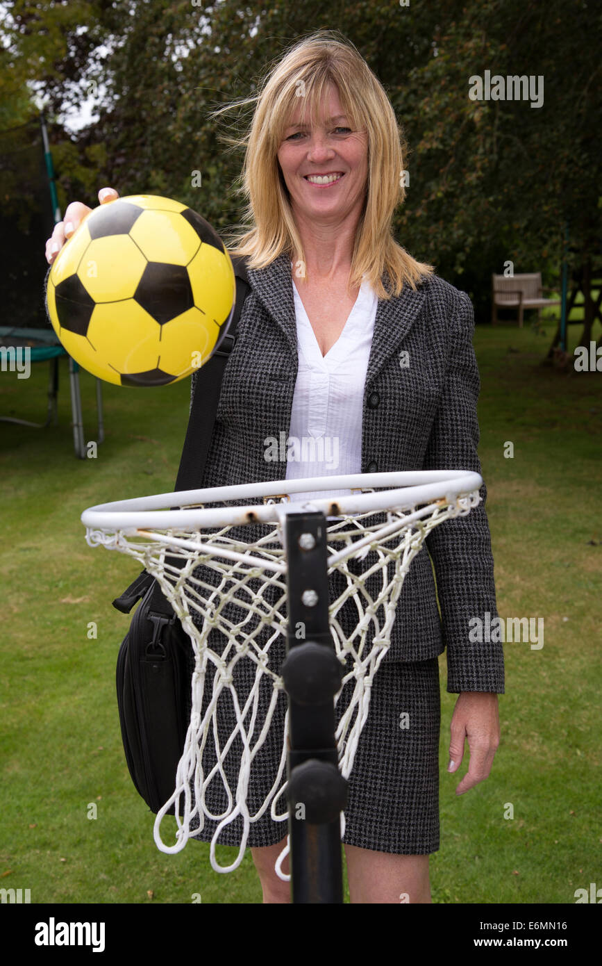 Businesswoman achieving her goal dropping a ball into a net Stock Photo