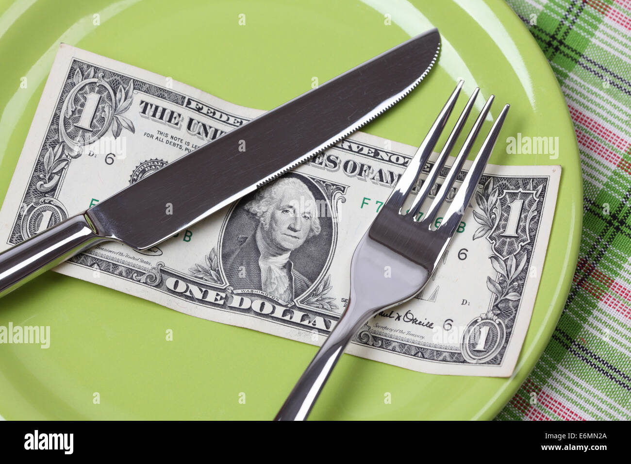 One Dollar Diet. One dollar on a plate with a knife and fork. Stock Photo
