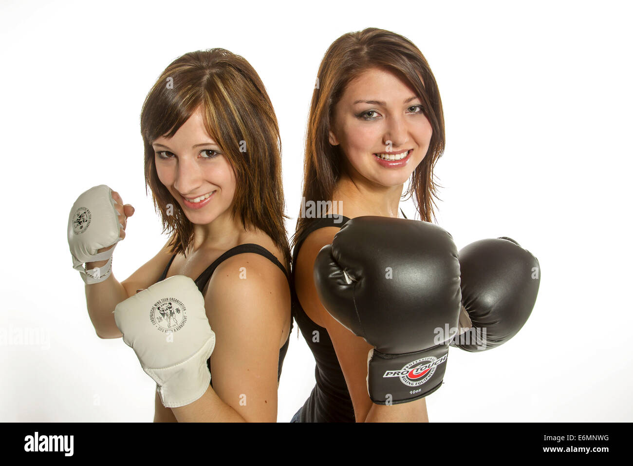 Two young women in sports clothing, one wearing Wing Chun gloves, the other wearing boxing gloves Stock Photo