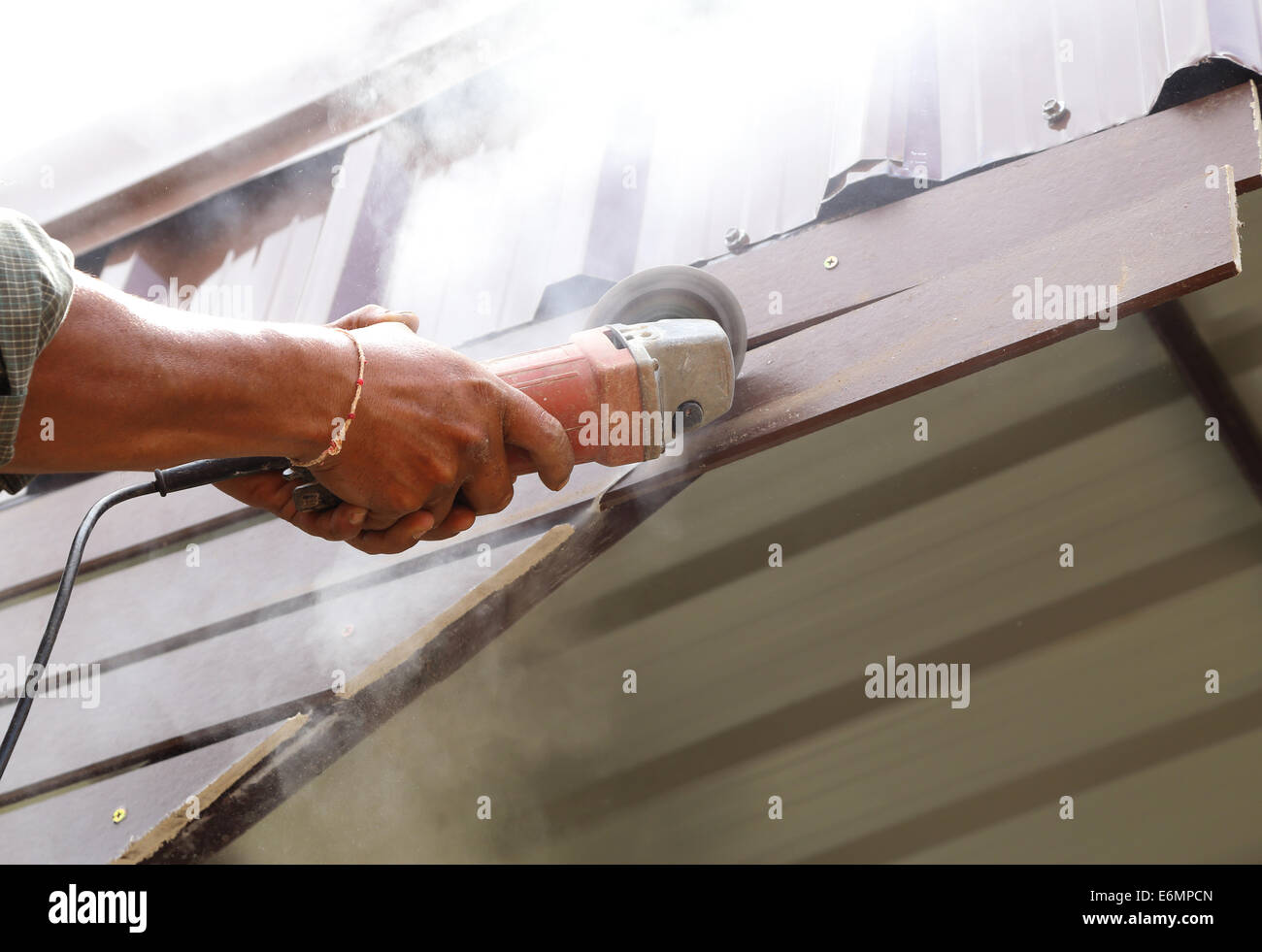 worker use small grinding tool for cutting wood construction Stock