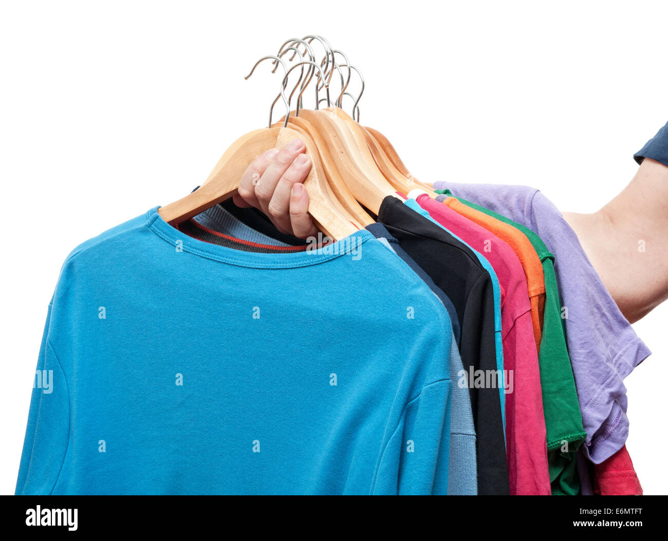 men hand holding hangers with sweaters and t-shirts Stock Photo
