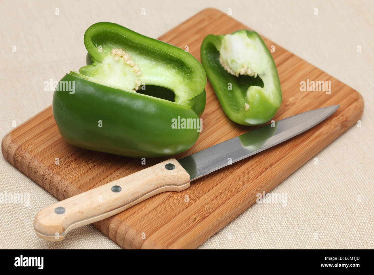 Green bell pepper on a cutting board with knife. Stock Photo