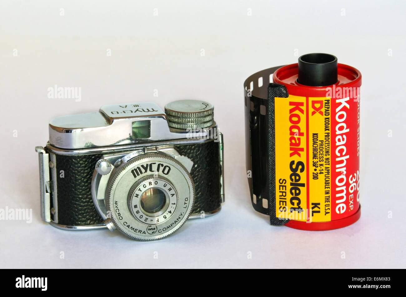 A Mycro subminiature camera next to a standard sized roll of 35mm film. Stock Photo