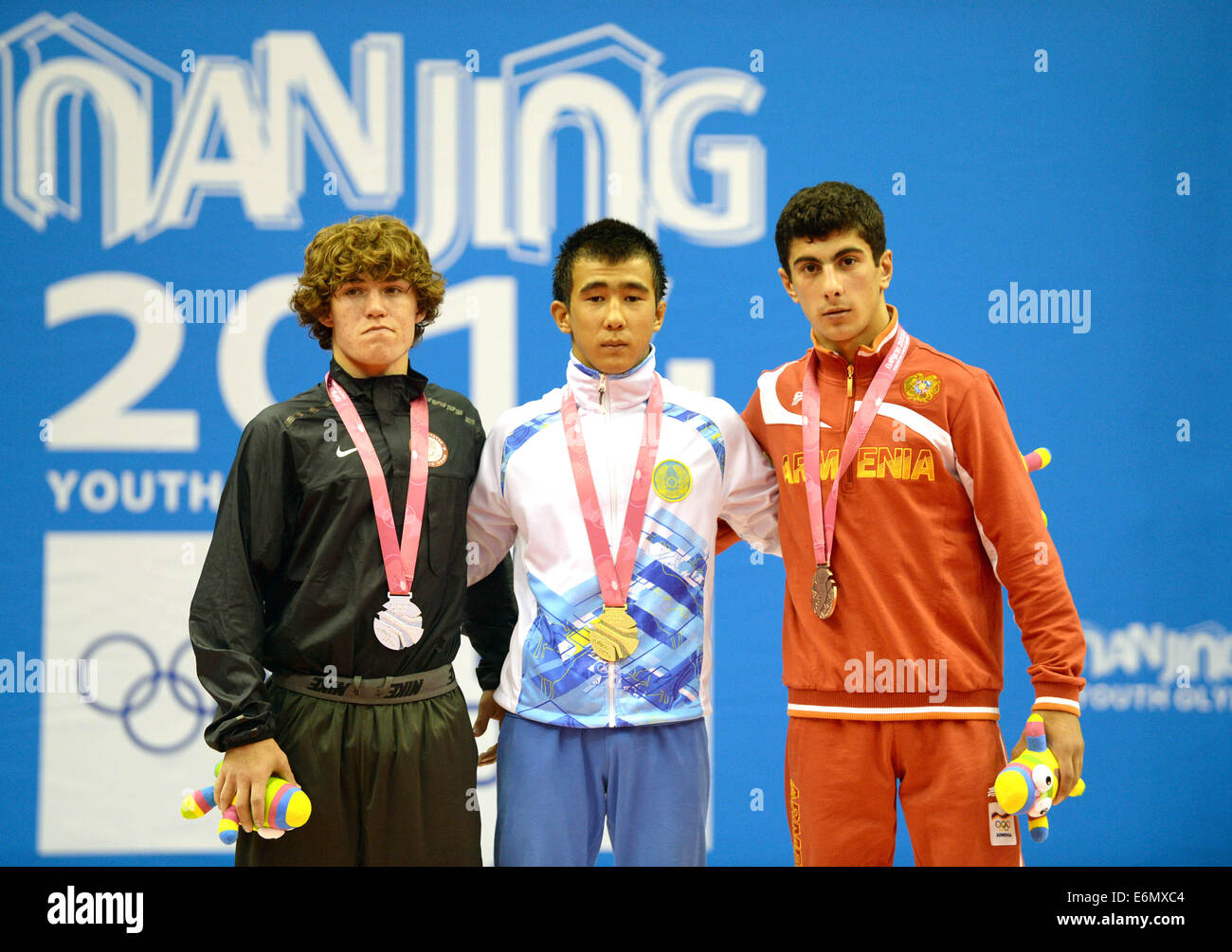 Nanjing, China's Jiangsu Province. 27th Aug, 2014. Gold medalist Mukhambet Kuatbek (C) of Kazakhstan, silver medalist Daton Fix (L) of United States of America and bronze medalist Vaghinak Matevosyan of Armenia stand on the podium during the awarding ceremony of men's freestyle 54-kg event of wrestling competition at Nanjing 2014 Youth Olympic Games in Nanjing, capital of east China's Jiangsu Province, on Aug. 27, 2014. Credit:  Zhao Peng/Xinhua/Alamy Live News Stock Photo