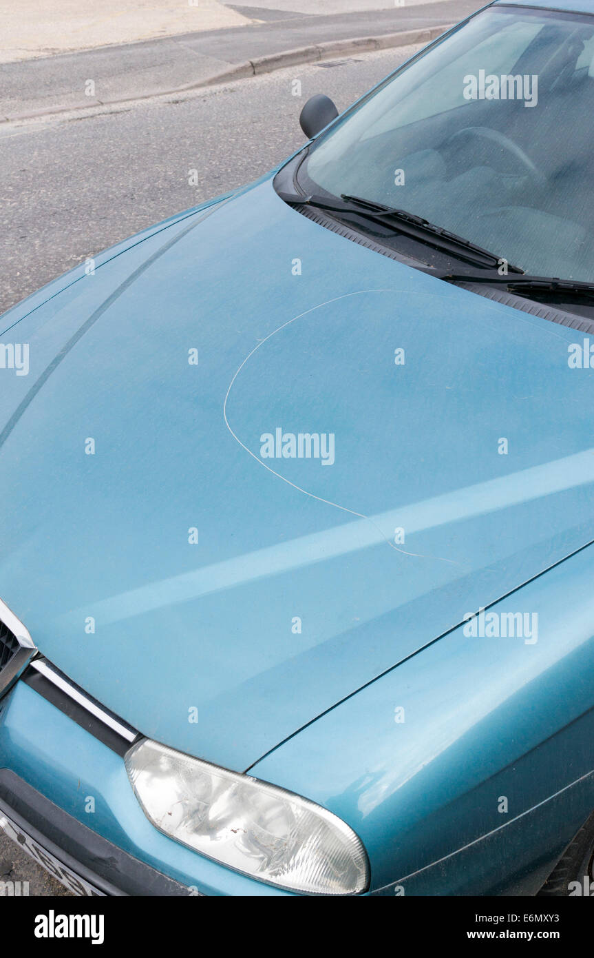 Scratched paint vandalized car bonnet UK Stock Photo