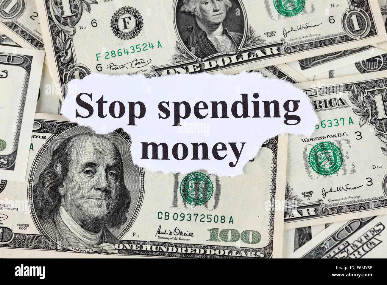Words 'Stop spending money' and dollar bills. Close-up. Stock Photo