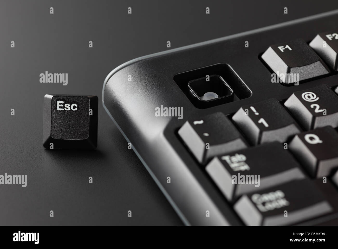 Key 'Esc' ran away from a black computer keyboard. Office Escape Concept. Stock Photo