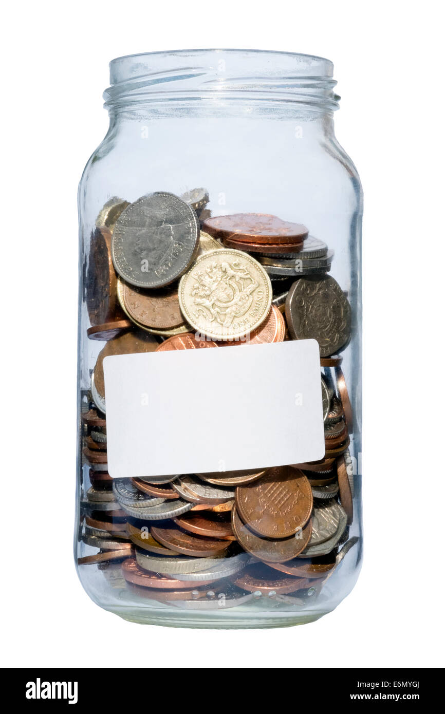 Jam jar full of coins, UK. Glass jar containing pounds & pennies savings. Stock Photo