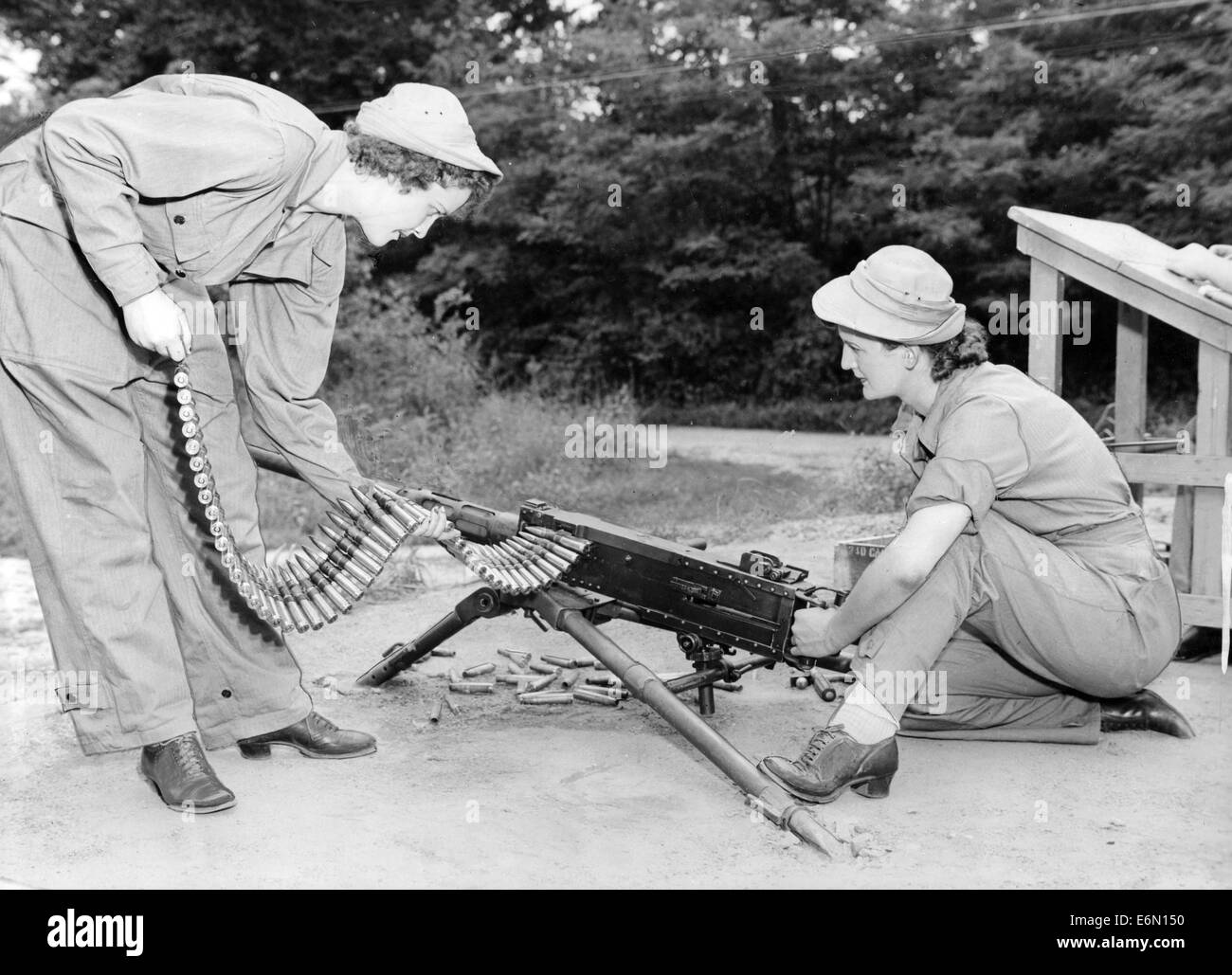 Two members of the American Women's Army Corp test fire a .50 Browning machine gun during WW11 Stock Photo