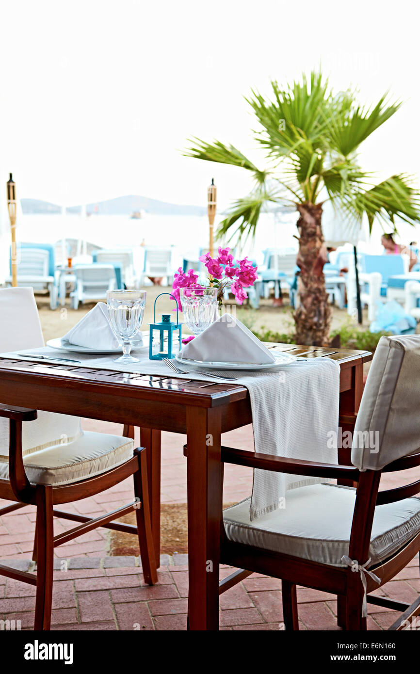 Exploring Turkish cuisine with an Al Fresco table and chairs set for beachside meal in Bitez, Turkey Stock Photo