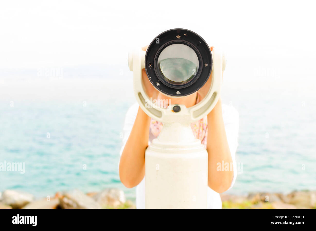 Woman looking through binoculars or telescope Stock Photo