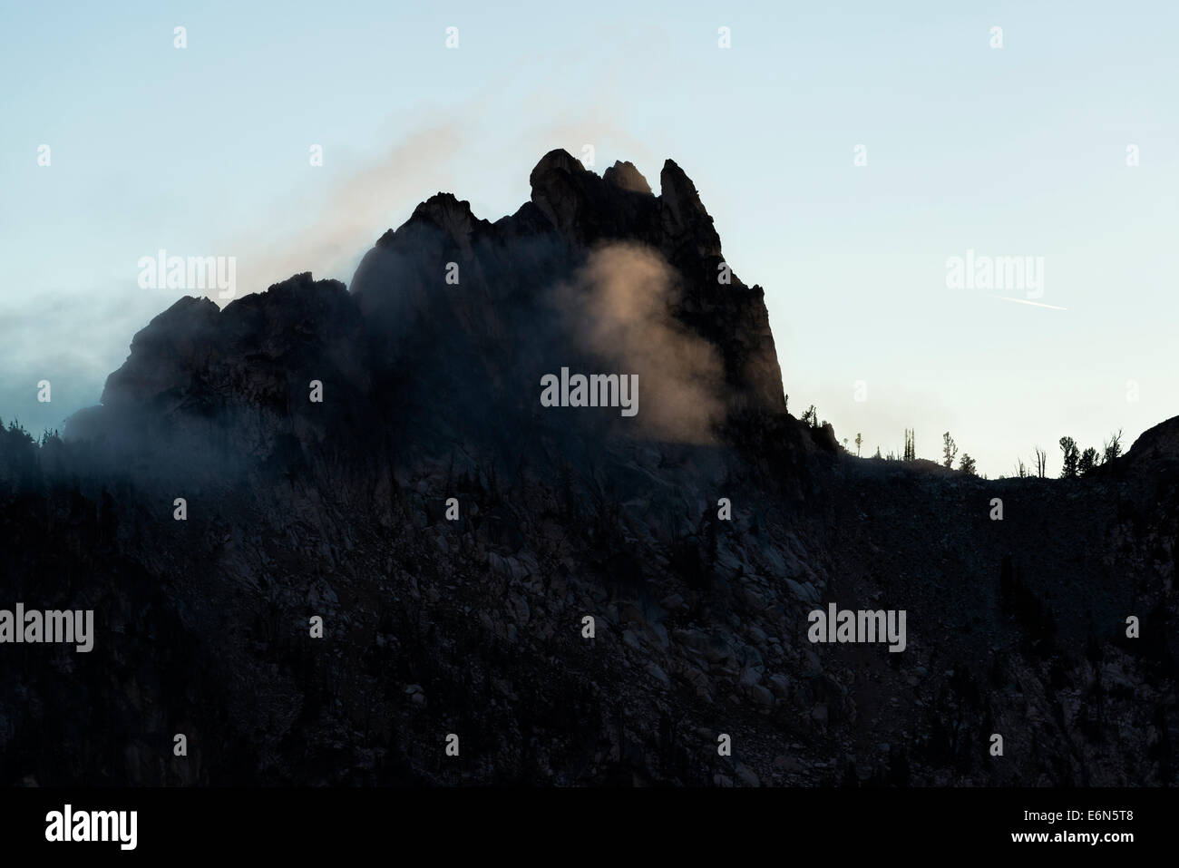A peak in the Sawtooth Mountains with mists at sunset. Stock Photo