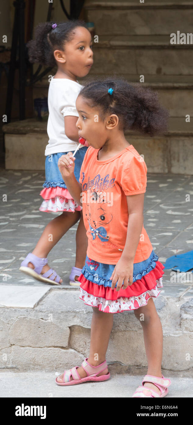 young Cuban girls sucking lollipops, Havana, Cuba Stock Photo