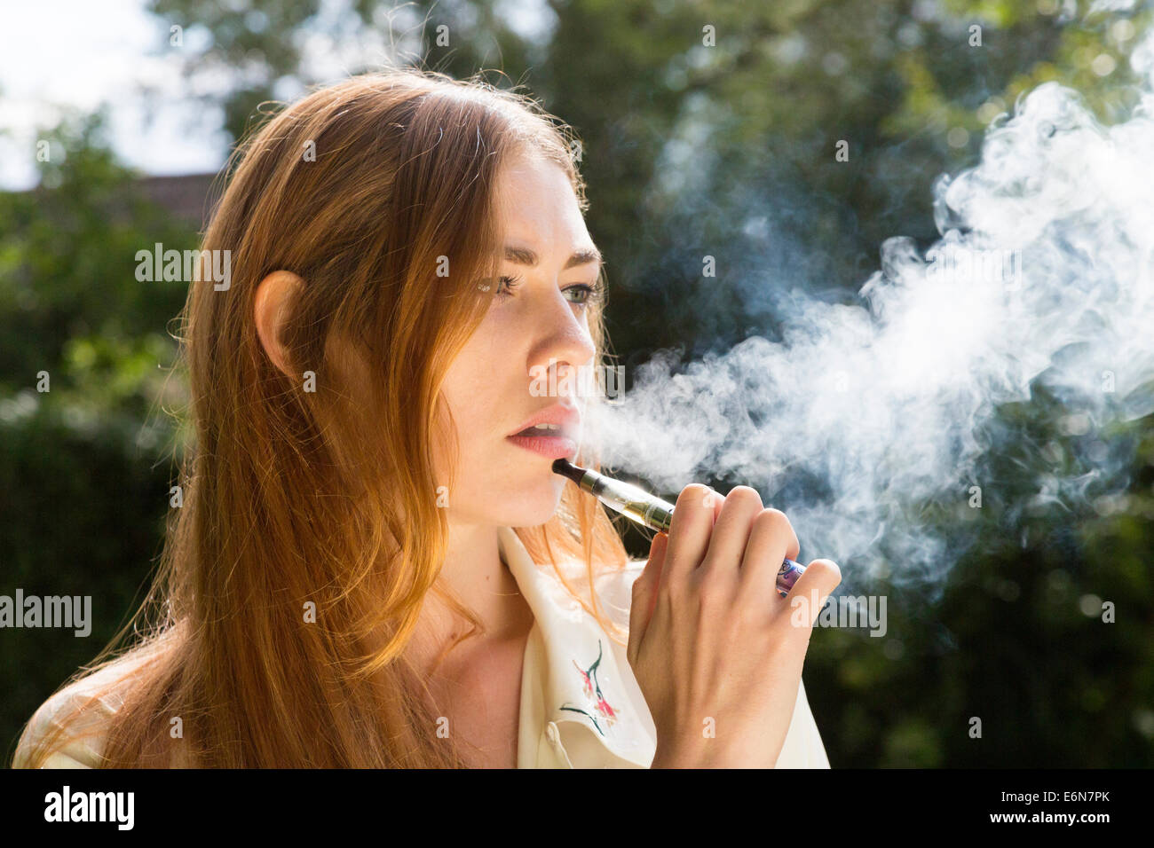 young woman smoking an electronic e-cigarette Stock Photo