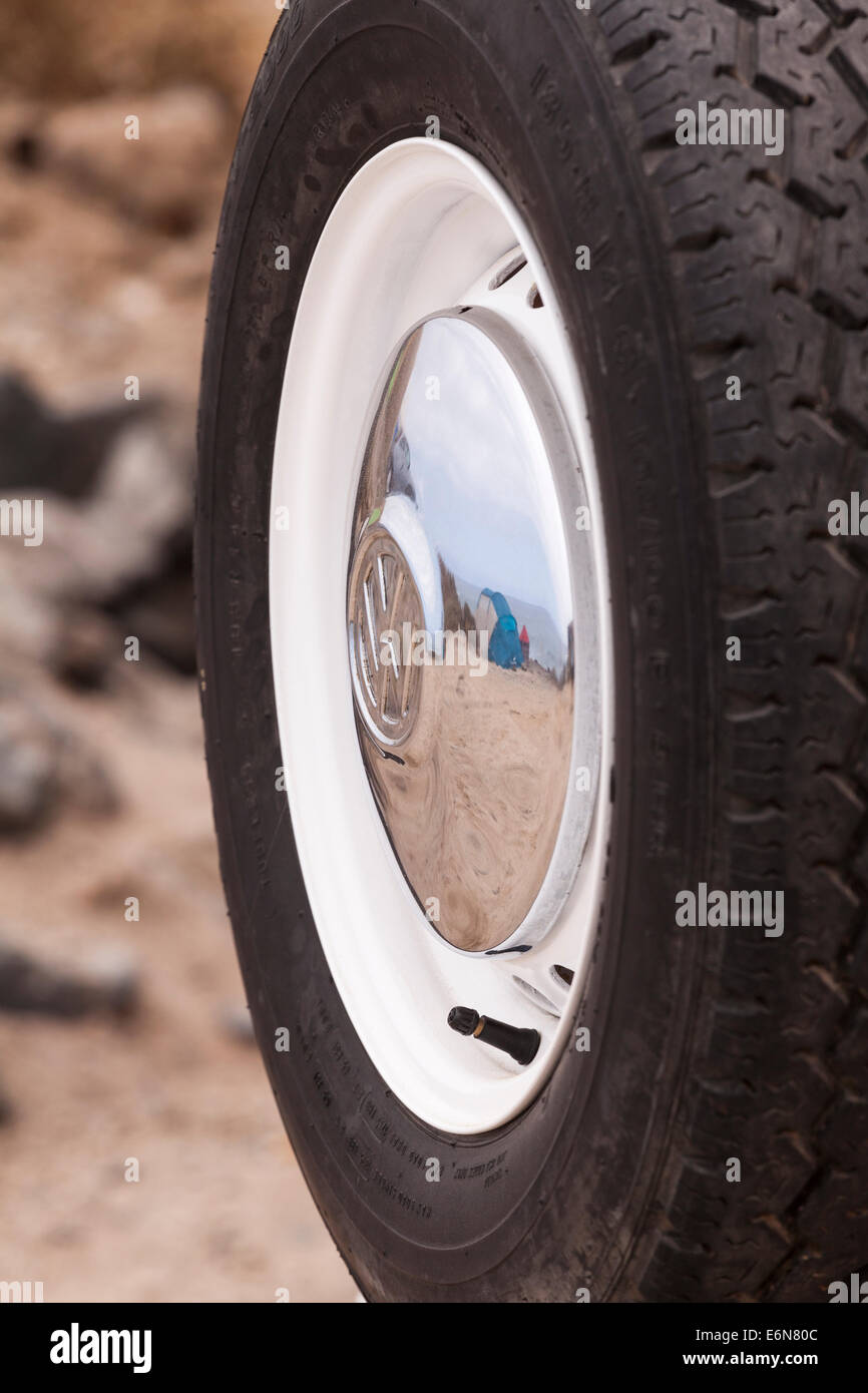 VW hubcap reflecting camping scene on a beach. Stock Photo