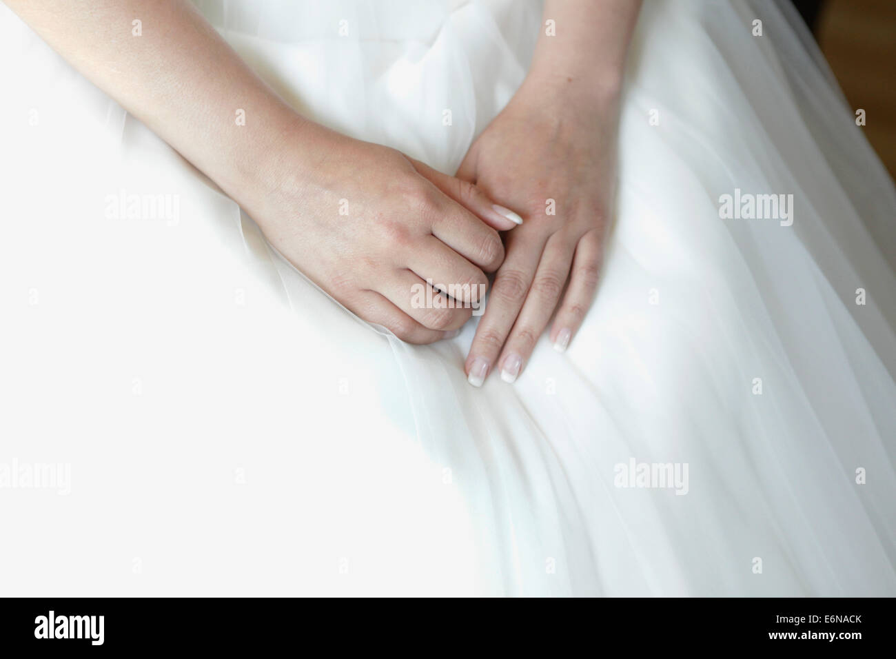 hands of the bride lying on the bridal gown Stock Photo