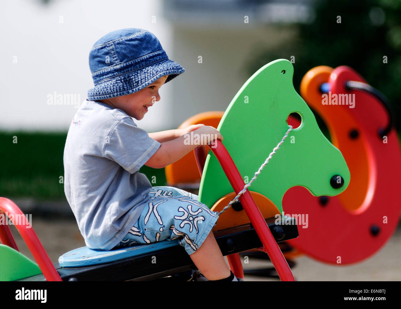 A smiling happy young boy playing in a playground Stock Photo
