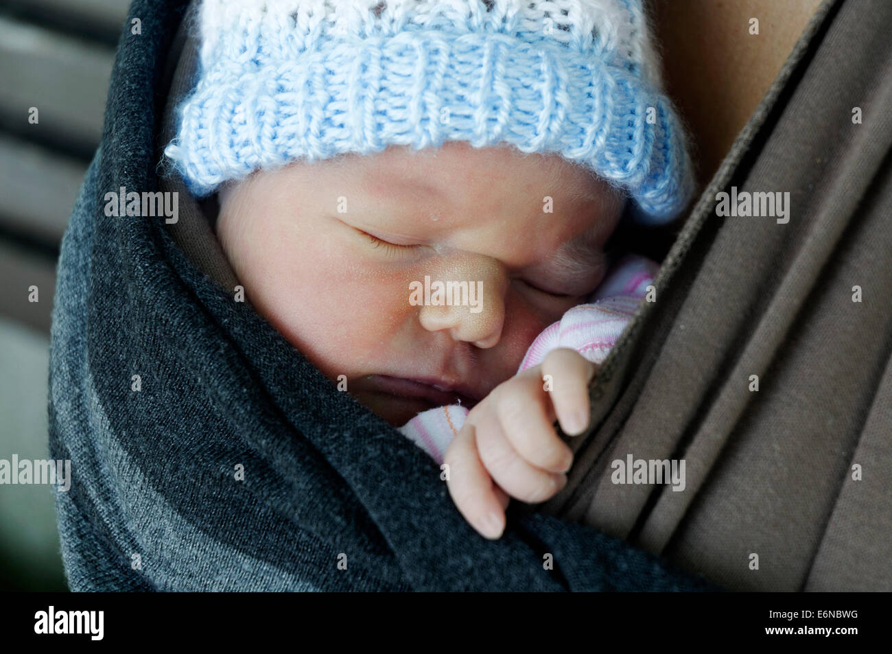 A newborn baby asleep in a baby carrier wrap Stock Photo Alamy