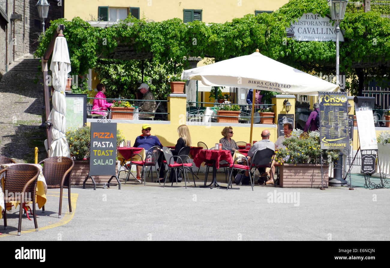 People eating outside a restaurant in Varenna, Italy Stock Photo