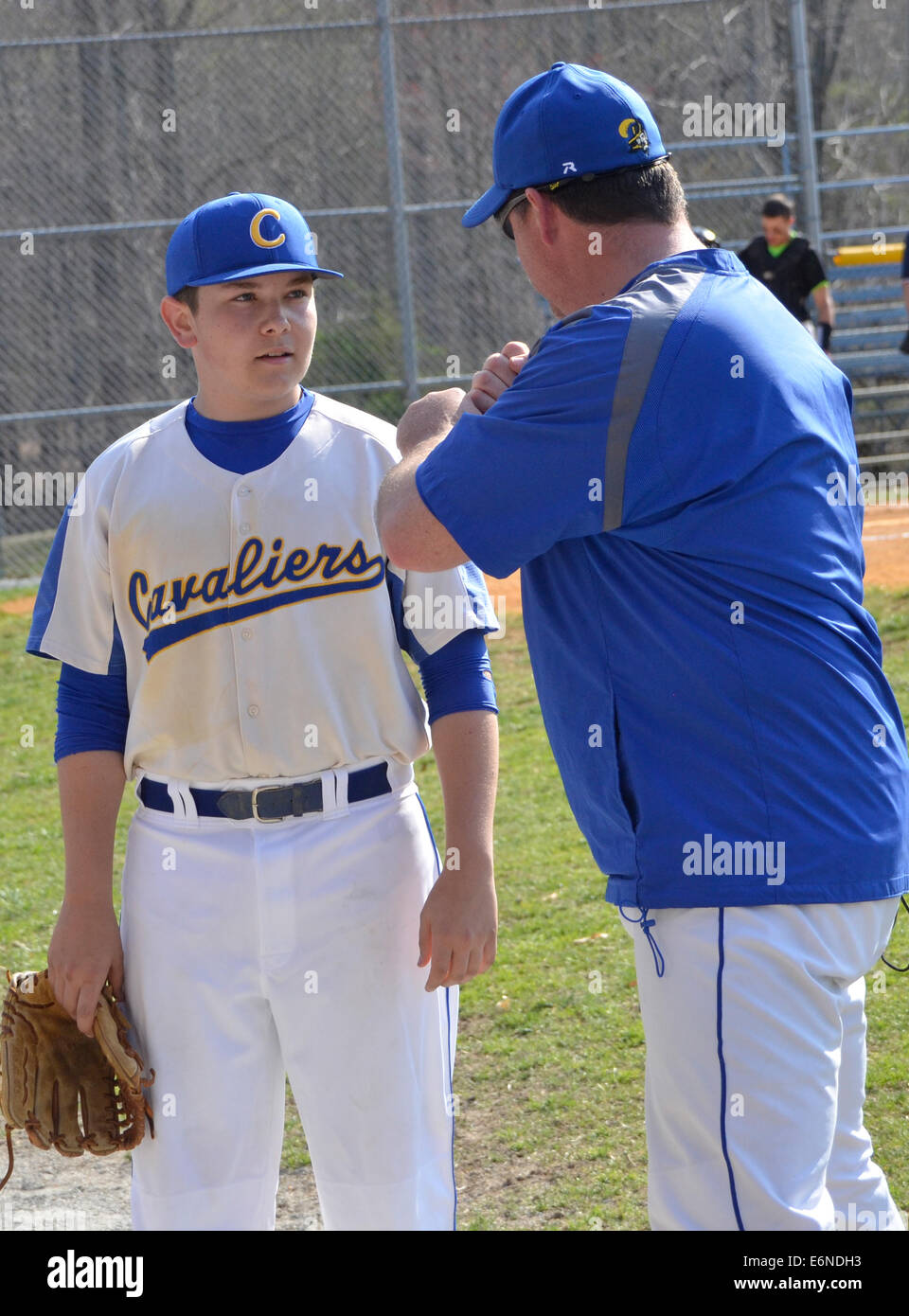 Boys youth baseball team coach talking with his team's players