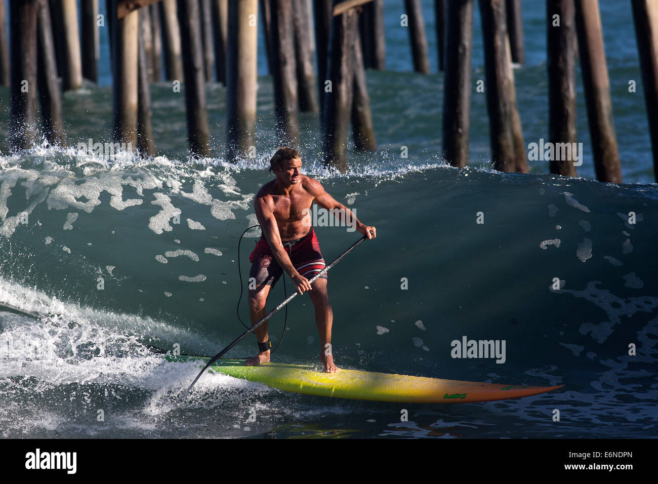 Malibu, California, USA. 27th Aug, 2014. Professional surfer Laird Hamilton surfs at the pier at Malibu Surfrider beach as big waves swelled by distant Hurricane Marie arrives at Southern California beaches. © Jonathan Alcorn/ZUMA Wire/Alamy Live News Stock Photo