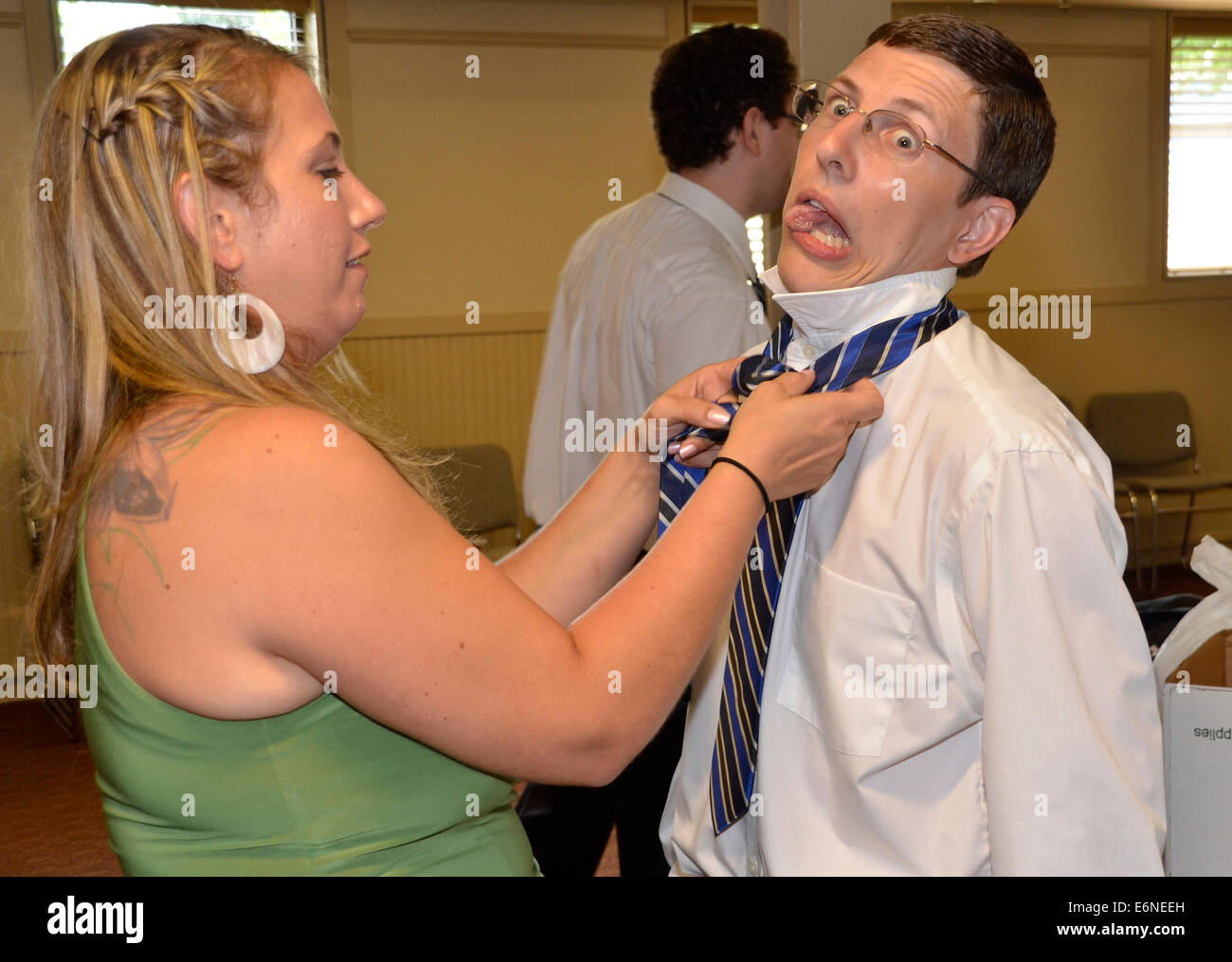 man goofs off as a woman tries to tie hs tie for him Stock Photo