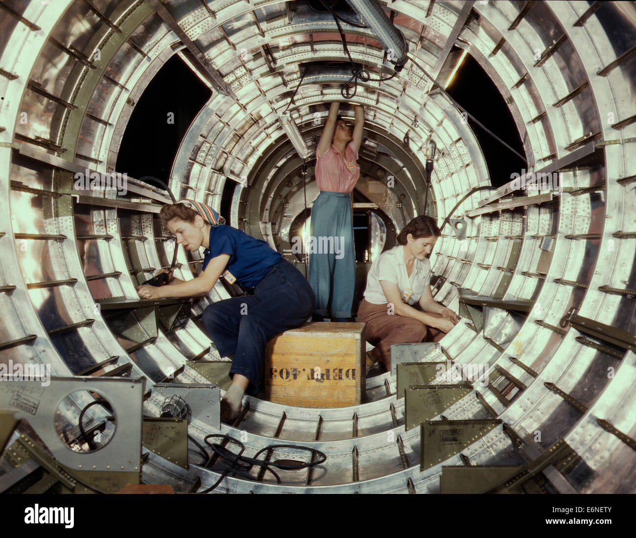 Women workers install fixtures and assemblies to a tail fuselage section of a B-17 bomber at the Douglas Aircraft Company plant, Long Beach, Calif. Better known as the 'Flying Fortress,' the B-17F is a later model of the B-17, which distinguished itself in action in the south Pacific, Germany and elsewhere. It is a long range, high altitude, heavy bomber, with a crew of seven to nine men, and with armament sufficient to defend itself on daylight missions, October 1942 Stock Photo