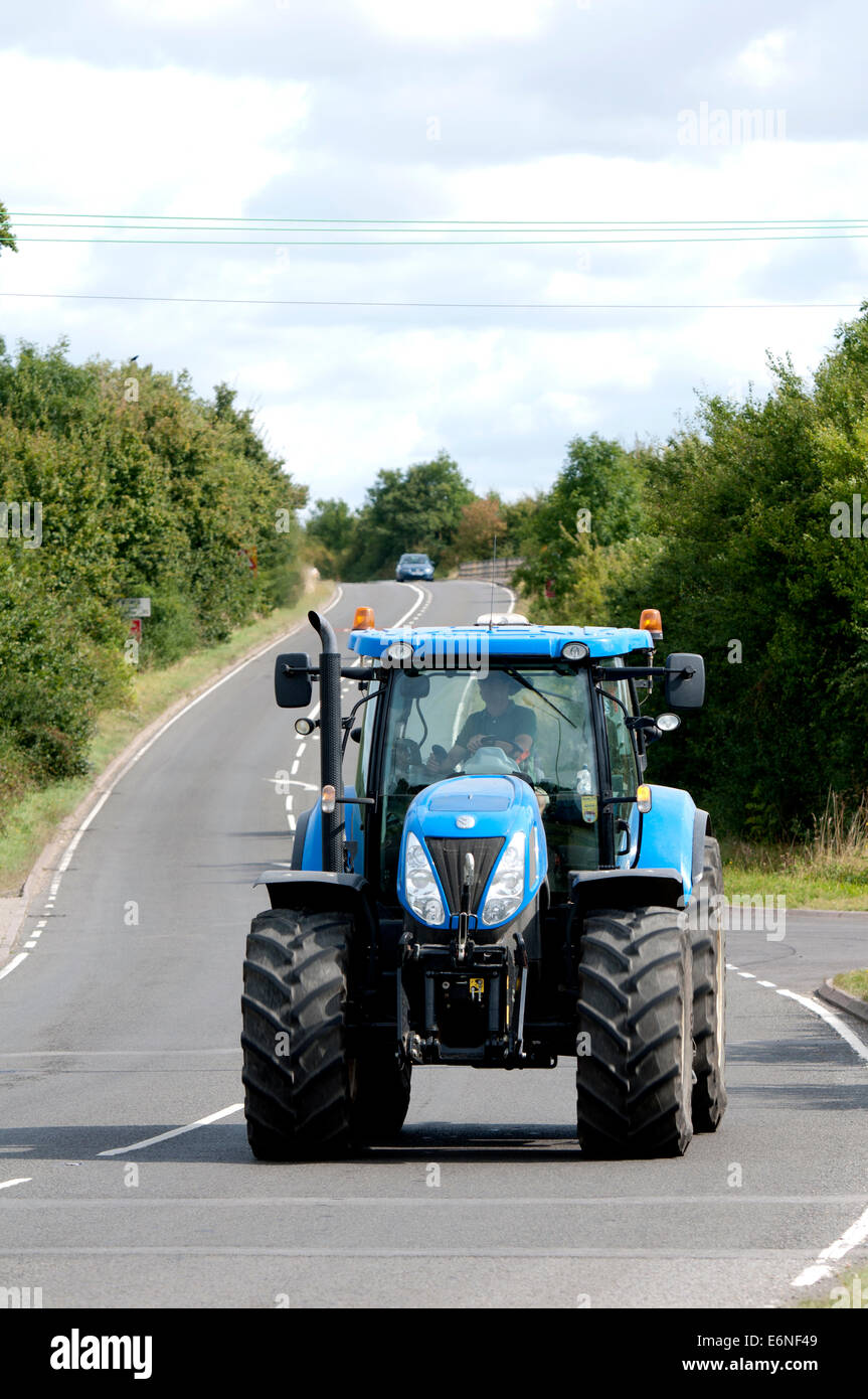 New Holland tractor on the Fosse Way road, Warwickshire, UK Stock Photo