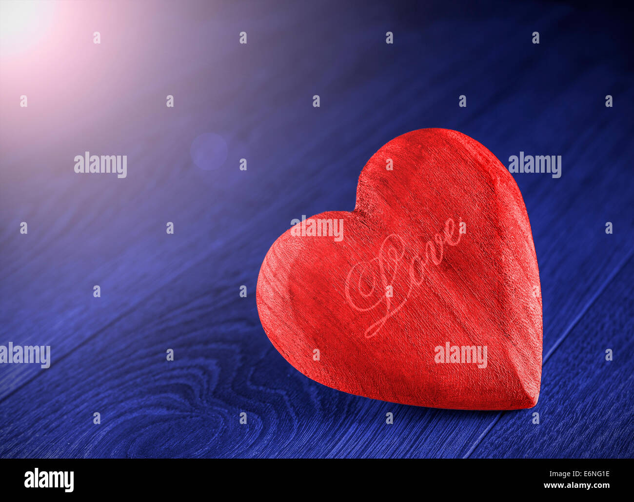 Red wooden heart on blue background. Stock Photo