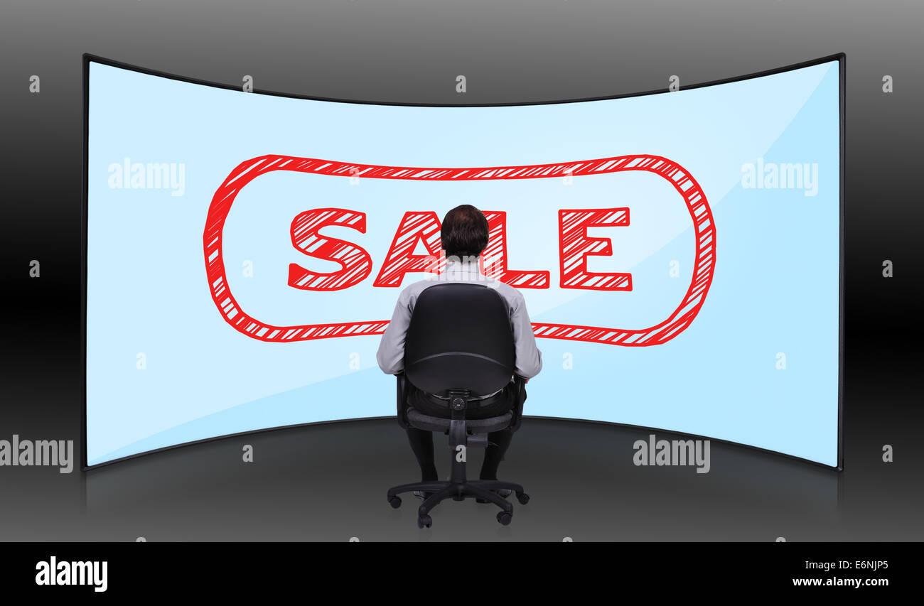 businessman sitting in movie house and looking at plasma with sale Stock Photo