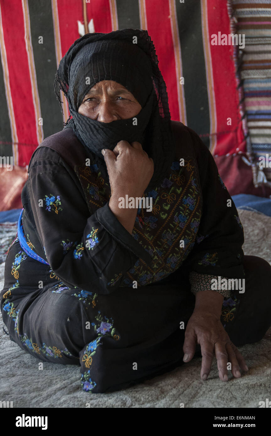 Bedouin grandmother seated on the dirt of her tent outside Amman, Jordan Stock Photo